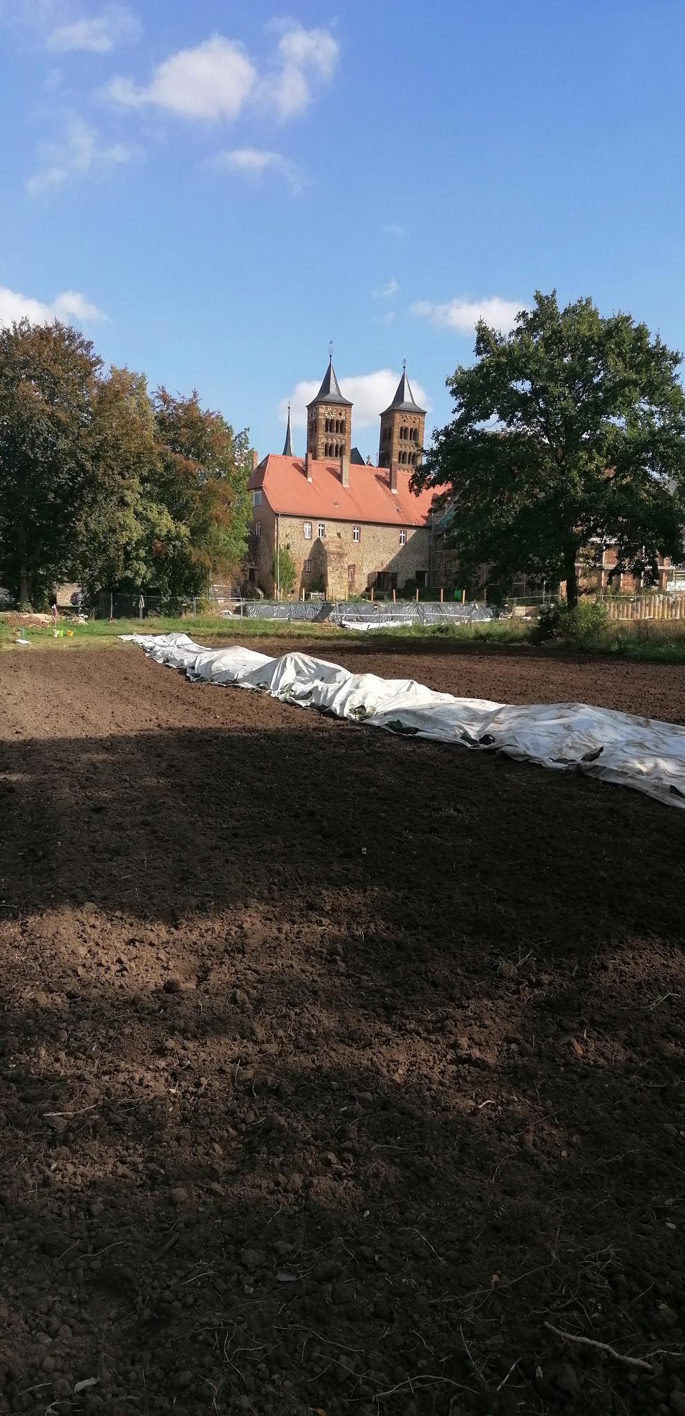 Während im Klostergarten die SOLAWI-Anbaufläche angelegt wird, entsteht die Tiefgarage (im Hintergrund) - Photo: ©KIKI e.V.